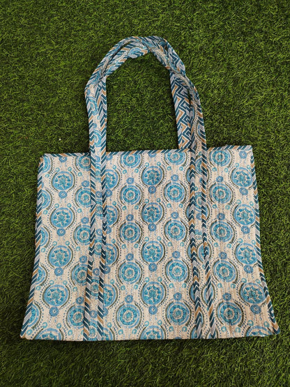 Tote bag with blue and beige pattern on a green grass background