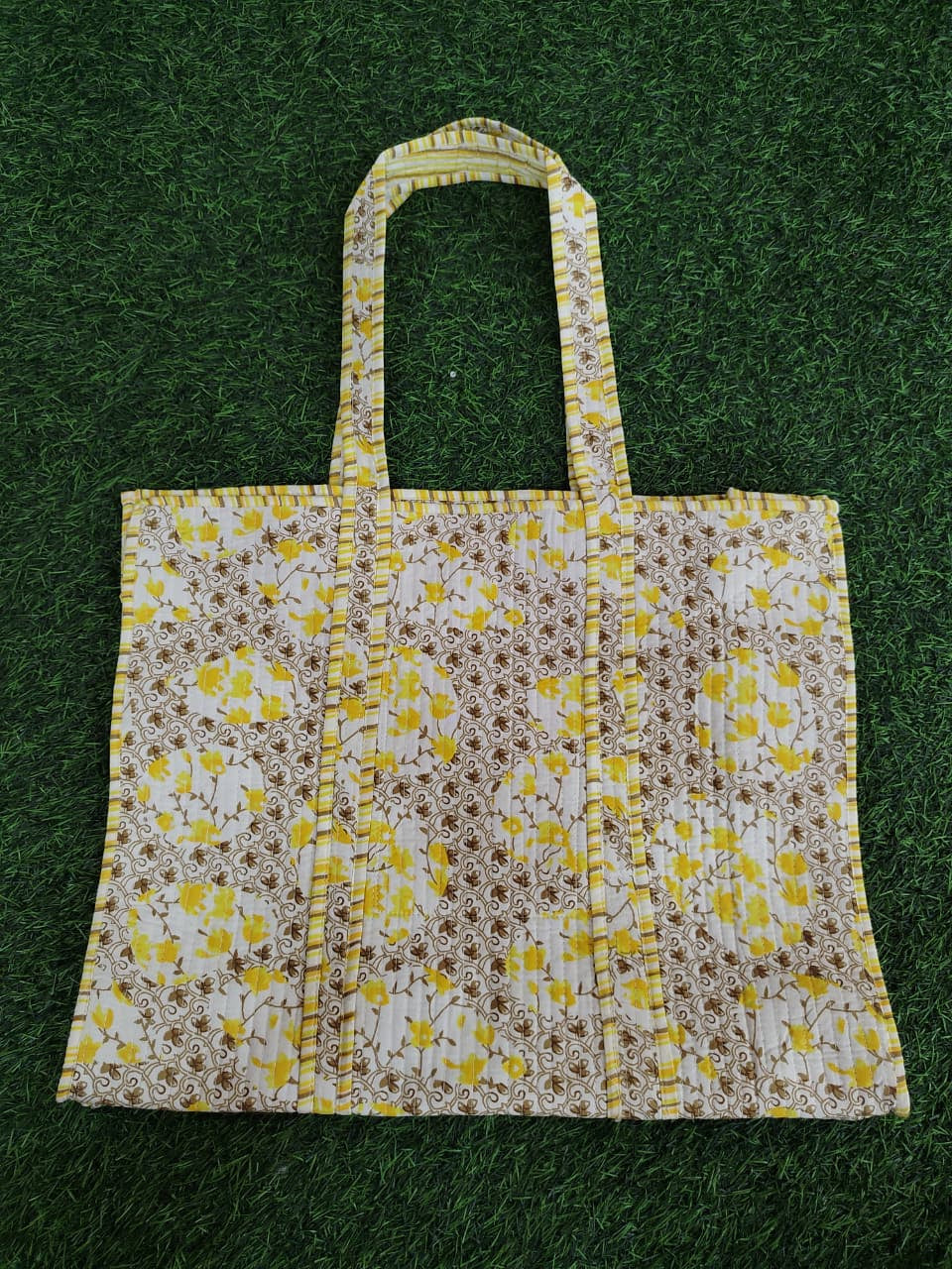 Floral patterned tote bag on a green grass background