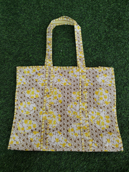 Floral patterned tote bag on a green grass background